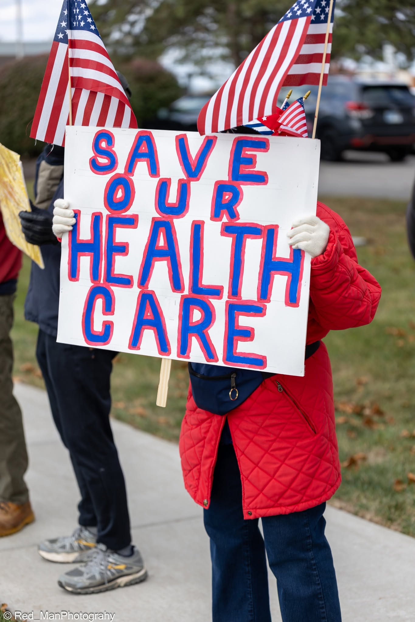 A community member holding a sign in support of healthcare